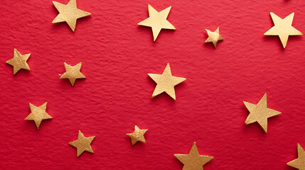 Obraz premium Brilliant scattered gold stars are displayed on a rich red surface creating a festive, celebratory atmosphere. The stars vary in size, sparkling brightly.
