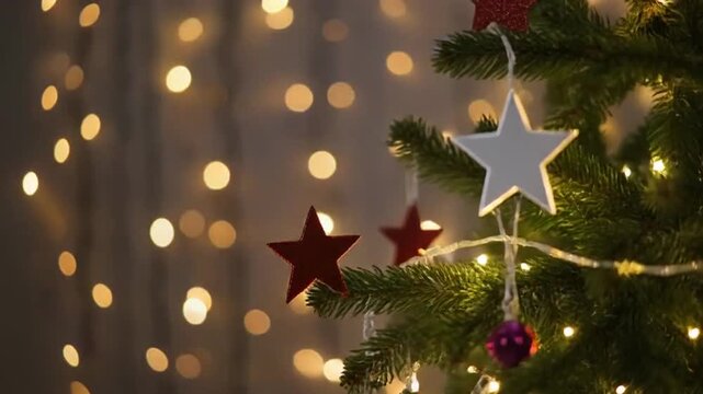 elegante de una peque&ntilde;a decoraci&oacute;n navide&ntilde;a compuesta por un &aacute;rbol de escritorio con efecto nevado y una estrella dorada con purpurina. Al fondo, luces c&aacute;lidas desenfocadas crean un ambiente acogedor