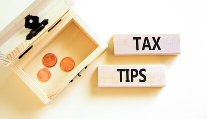 Tax tips symbol. Concept word Tax tips on beautiful wooden blocks. Beautiful white paper background. Beautiful wooden chest with coins. Business tax tips concept. Copy space.