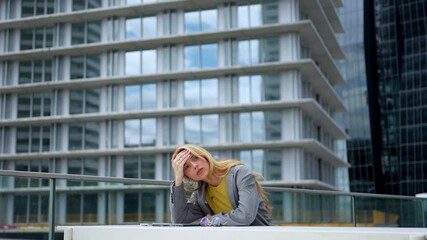 Stressed businesswoman suffering from a headache outdoors near an office building - Powered by Adobe