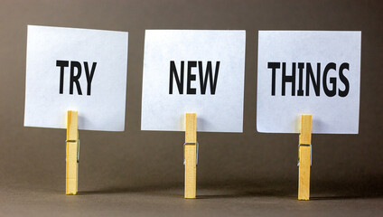 Try new things symbol. Concept words Try new things on beautiful white paper on wooden clothespin. Beautiful grey background. Business motivational lifestyle try new things concept. Copy space.