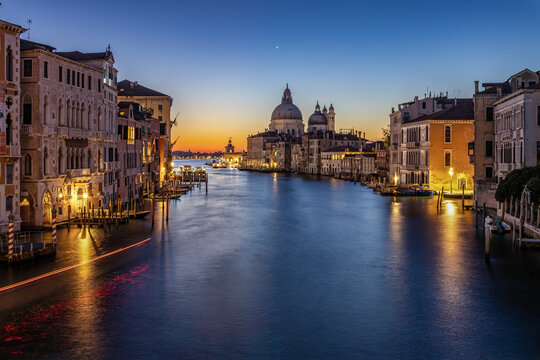 Morning in Venice - typical view from the Accademia bridge on the Grand canal towards the Basilica di Santa Maria della Salute - long exposure before sunrise with blue and orange sky