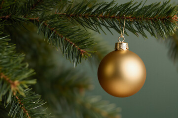 A shimmering gold bauble adorns a Christmas tree, symbolizing festive joy and holiday spirit.