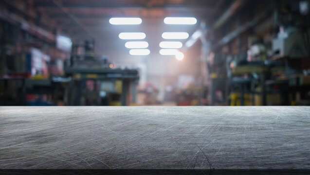 Scratched steel table top and background of a factory with cold light