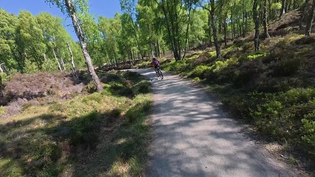 nice senior woman riding her electric mountain bike  in the highlands of Cairn Gorms National Park , Scotland, UK