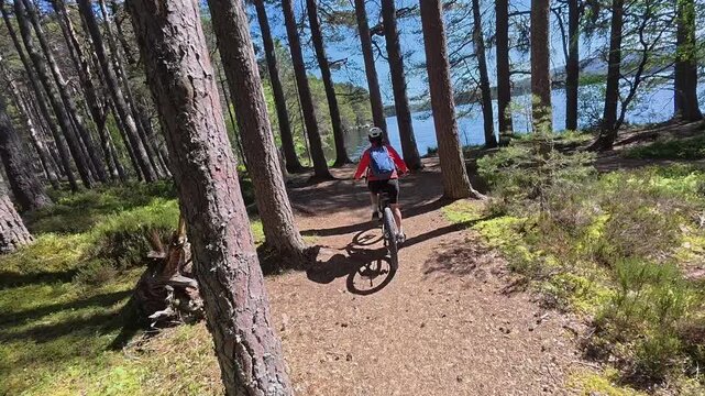 nice senior woman riding her electric mountain bike  in the highlands of Cairn Gorms National Park , Scotland, UK