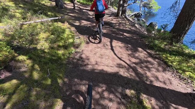 nice senior woman riding her electric mountain bike  in the highlands of Cairn Gorms National Park , Scotland, UK