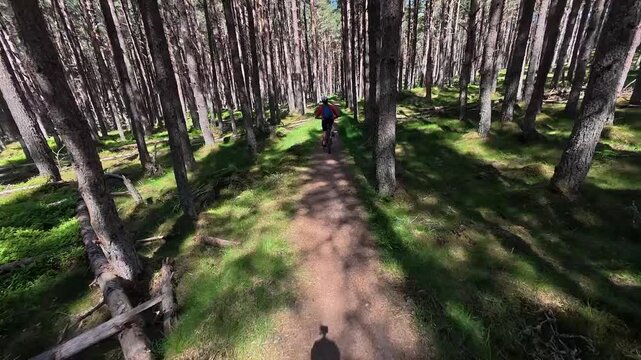 nice senior woman riding her electric mountain bike  in the highlands of Cairn Gorms National Park , Scotland, UK