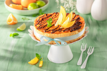 Tasty and fresh cheesecake with chocolate and orange fruits.