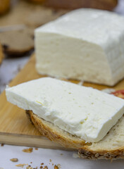 Block of Fresh White Cheese on a Wooden Cutting Board.