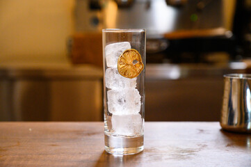 Highball glass with ice and dried lime garnish