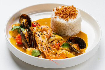 Enjoy a rich seafood curry with shrimp, mussels, veggies, and rice