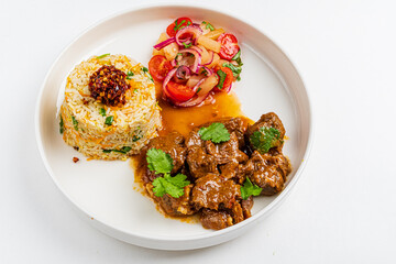 Tender beef stew accompanied by seasoned rice and a vibrant salad, creating a delicious meal