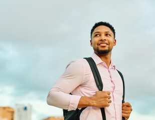 Portrait of a young man businessman or tourist  walking down the street, surrounded by modern corporate office buildings