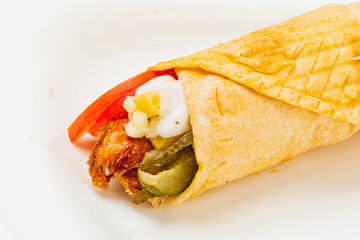 Enjoying a savory wrap bursting with crispy chicken, fresh tomatoes, and zesty pickles