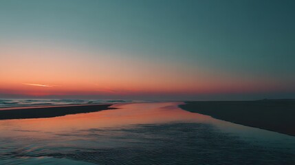 Fototapeta premium Dramatic twilight colors illuminate the vast expanse of water and sky at the horizon