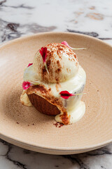 A warm dessert topped with creamy ice cream and delicate petals, creating a beautiful visual treat