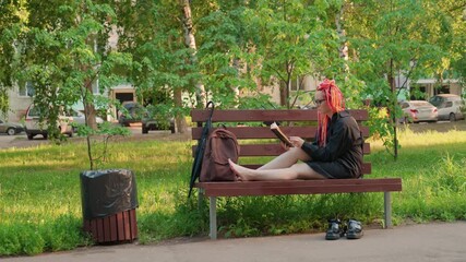 casual summer reading, lady enjoying sunny park with her book, youthful woman leisurely reading barefoot on park bench, relaxed female sunbather casually immersed in book during sunny park day