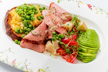 Enjoy a delicious brunch of creamy scrambled eggs, tender ham, and fresh, colorful veggies