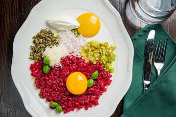 A vibrant plate of tartare and herbs invites food lovers in a cozy setting