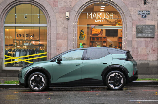 A green car is parked in front of a Marush store
