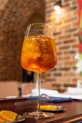 Sparkling drink filled with ice and bright orange slices sits invitingly on a table