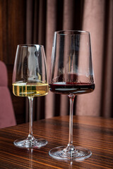 Naklejka premium Two beautifully shaped glasses hold fresh white and deep red wine, showcasing their vibrant colors