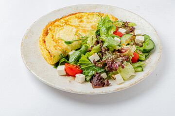 A scrumptious omelet paired with a colorful salad, showcasing fresh greens and juicy tomatoes