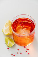 A colorful beverage rests on a smooth surface, accompanied by fresh lime and lemon slices