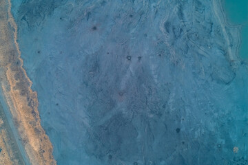 Aerial top down view of blue pockmarked sludge surface with small craters. Toxic waste texture and surreal alien landscape background.