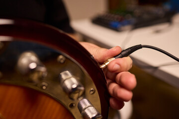 Musician setting up equipment, Preparing bass guitar for recording, Electric bass player organizing gear in studio, Closeup of musician tuning and adjusting bass instrument