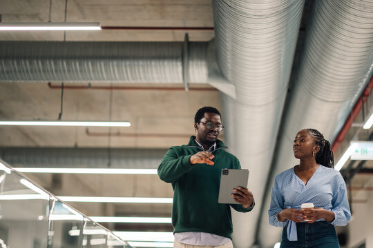 Business colleagues collaborating using tablet in modern office - Powered by Adobe