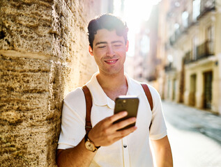 Young man enjoys sunny day while using smartphone in urban setting, highlighting her joy and connection to the world around her