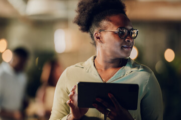 Businesswoman working late on tablet in office