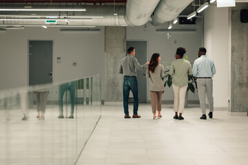 Diverse business professionals walking through modern office hallway