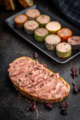 Pate on a slice of bread on black table.