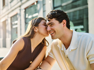 Young couple enjoying conversation and coffee together and taking a selfie with a smartphone at an outdoor urban cafe table