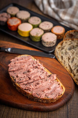 Pate on a slice of bread on wooden table.