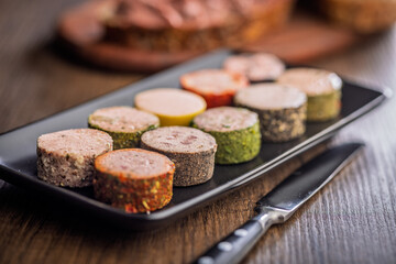 Liver pate with cranberries on plate on wooden table.