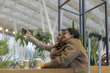People taking selfie together in modern cafe