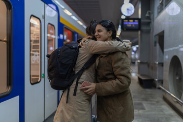 Women embracing on train platform before departure
