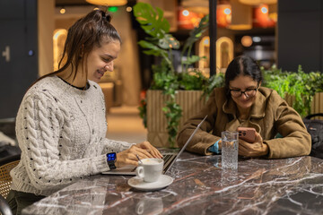 Young woman confidently working on laptop at cafe