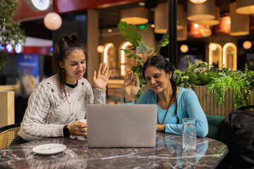 Women having video call in cafe