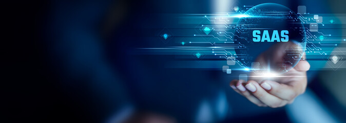 SaaS concept, Businessman hold SaaS text. cloud delivery, online access, scalable apps, subscription model, digital efficiency, modern software