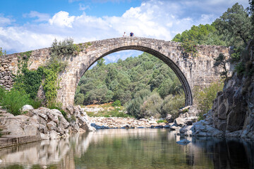 Imposing, high, historic, monumental Roman stone bridge structure.
