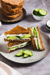 English sandwich with cucumber, butter and cheese on grain bread on a plate vertical view