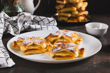 Sweet puff pastries with pineapple in powdered sugar on the table