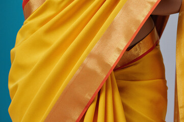 Texture of yellow silk sari for festival. Traditional Indian fashion background.