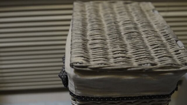Sorting dirty laundry into a wicker basket at home