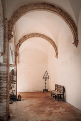 Ancient Spanish Monastery Arches Overlooking A Tranquil Wooden Bench